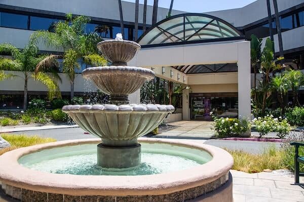 Three-tiered fountain in front of entrance to Laguna Treatment Center