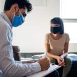 doctor meeting with patient wearing mask